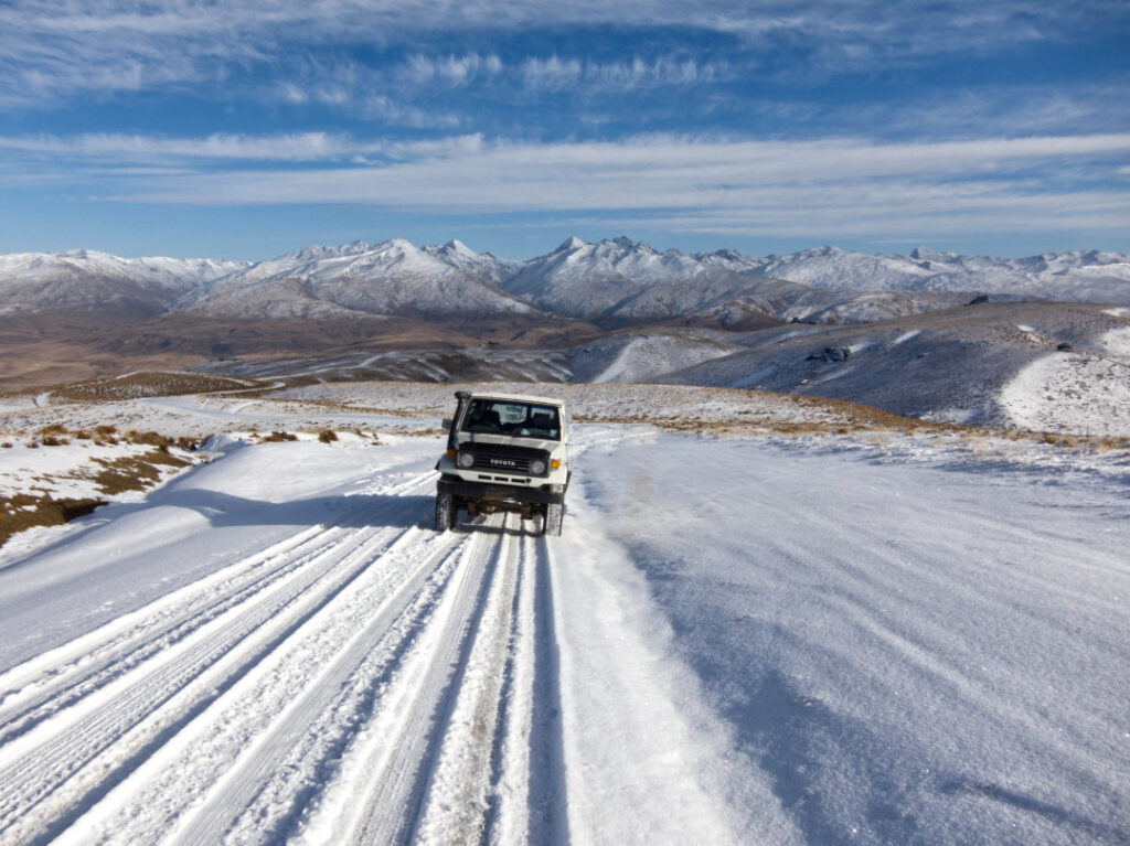 The summit of Duffers Saddle, the highest public road in Central Otago. Looking at a 70 Series LandCruiser against the backdrop of the hidden side of the Remarkables mountain range
